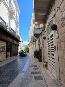 an alley with buildings and a car parked on the street at CASA NiNì in Trani