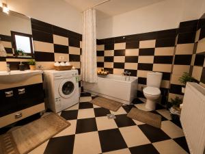 a bathroom with a checkered bathroom with a washing machine at Casa TOP Cristina in Poiana Teiului