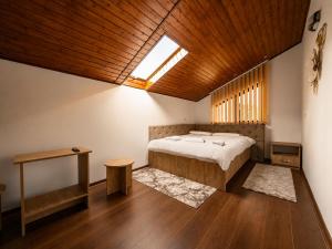 a bedroom with a bed and a wooden ceiling at Casa TOP Cristina in Poiana Teiului