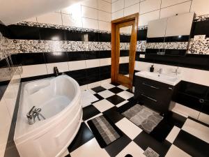 a black and white bathroom with a tub and sink at Casa TOP Cristina in Poiana Teiului +34 photos