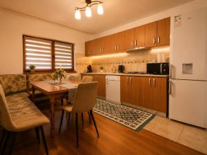 a kitchen with a table and a refrigerator at Casa TOP Cristina in Poiana Teiului