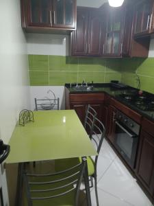 a small kitchen with a green table and chairs at Selma Space in São Filipe
