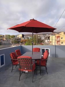 a table and chairs under an umbrella on a roof at Selma Space in São Filipe