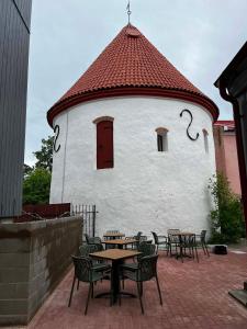 a building with tables and chairs and a red roof at Old town apartment in Pärnu