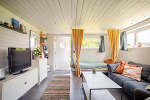 a living room with a couch and a tv at Cozy summer apartment in Archipelago in Öckerö