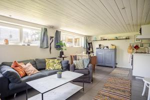 a living room with a couch and a table at Cozy summer apartment in Archipelago in Öckerö