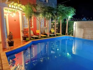 a swimming pool in front of a house at night at Hary's Aparthotel in Toliara