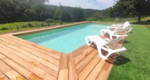 a group of chairs sitting next to a swimming pool at Casa dos Carballos in Covelo