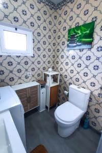 a bathroom with a toilet and a sink at Quinta do Norte - Biscoitos in Biscoitos