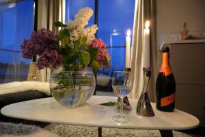 a table with a vase of flowers and two wine glasses at Solvesborg Houseboat with Harbour Views - Sleeps 4 in Sölvesborg