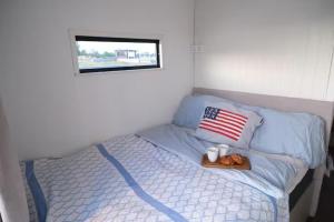 a bed with a tray of food and an american flag at Solvesborg Houseboat with Harbour Views - Sleeps 4 in Sölvesborg +2 photos