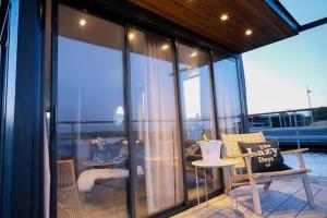 a balcony with glass walls and a table and a chair at Solvesborg Houseboat with Harbour Views - Sleeps 4 in Sölvesborg