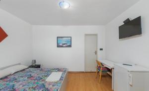 a bedroom with a bed and a desk with a computer at Miljak in Duće