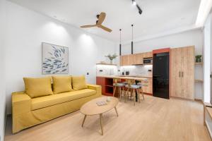 a living room with a yellow couch and a kitchen at Dock 38 Apartments Collection in Piraeus