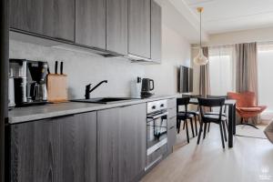 a kitchen with wooden cabinets and a table with chairs at Äkäsentie 1 A 211 by Holiday in Lapland in Äkäslompolo