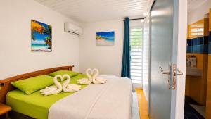two towels on a bed in a room at L'Ecrin d'Oliv - Jardin, Accès plage, Calme assuré in Grand-Bourg