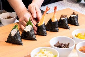 a person is preparing sushi on a cutting board at Richmond Hotel Nagoya Shinkansen-guchi in Nagoya