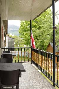 a balcony with a table and chairs and a flag at Guest House Adelina in Mestia