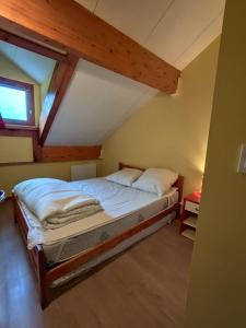 a bedroom with a bed in a attic at L'Esprit Chalet in Ustou
