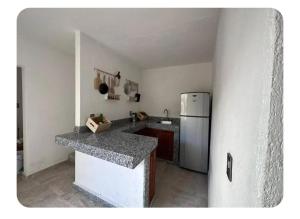 a kitchen with a counter and a refrigerator at Casa Don Alfonso in Cuernavaca