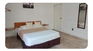 a bedroom with a large bed with white sheets and pillows at Casa Don Alfonso in Cuernavaca