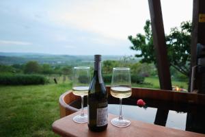a bottle of wine and two glasses on a table at Pajkos Présház in Bakonycsernye