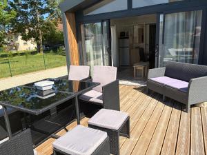 a patio with a table and chairs on a deck at Chalet Bois in Torcy-le-Petit