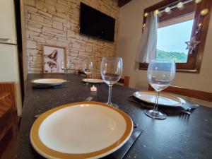 a table with a plate and wine glasses on it at L'Esprit Chalet in Ustou