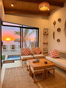 a living room with a view of the ocean at El Rubio Beach Bungalows in Zorritos +18 photos