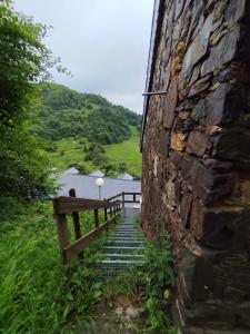 a stone building with a staircase next to a wall at L'Esprit Chalet in Ustou