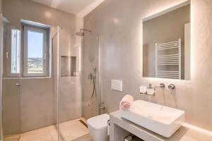 a bathroom with a sink and a shower and a toilet at Villa Ariadni Paros in Isterni +7 photos