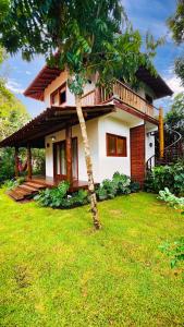 a house with a tree in front of it at Casa Miava - Studio 1 - Cozy place a few meters from the beach in Marau