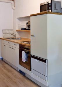 a kitchen with a white refrigerator and a stove at Appartement Archimedes - Modernes Wohnen in historischer Drostei im Südharz in Walkenried