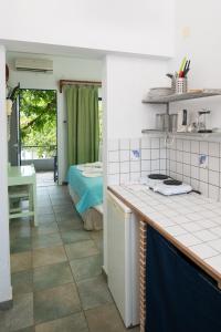 a kitchen with a counter and a room with a bed at Ikion Studios in Steni Vala Alonissos