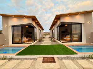 a villa with a swimming pool and a house at El Rubio Beach Bungalows in Zorritos