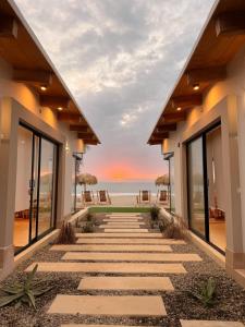 a walkway to the beach at sunset at El Rubio Beach Bungalows in Zorritos