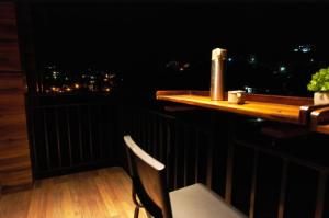 a table and a chair on a balcony at night at At Venue Groups in Kodaikānāl
