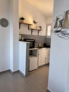 a kitchen with white cabinets and a microwave at Aether seaview in Benitses +28 photos