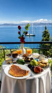 a table with food and drinks on a table with a view of the water at Aether seaview in Benitses