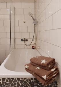 a bathroom with a bath tub with towels on it at Appartement Archimedes - Modernes Wohnen in historischer Drostei im Südharz in Walkenried +10 photos