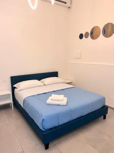 a bedroom with a blue bed with two towels on it at Atmosfere 19 in Sant'Egidio del Monte Albino