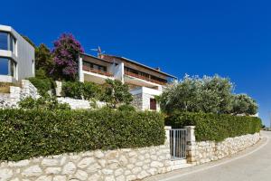 a house on a hill with a stone wall at Villa Porthos in Hvar