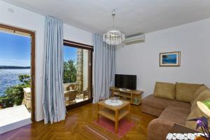 a living room with a couch and a large window at Villa Porthos in Hvar