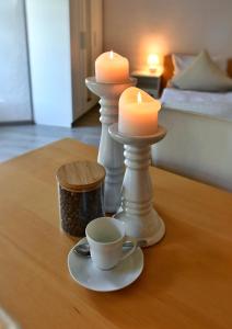 two candles and a cup of coffee on a table at Appartement Archimedes - Modernes Wohnen in historischer Drostei im Südharz in Walkenried