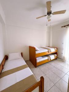 a room with two beds and a ceiling fan at Elizabeth's Home in Flogita