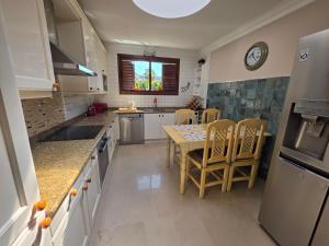 a kitchen with a table and chairs and a clock at Villa Torbellino, Diseño, Privacidad y Confort in La Playa de Tauro