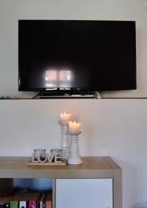 two candles on a table under a tv at Appartement Archimedes - Modernes Wohnen in historischer Drostei im Südharz in Walkenried