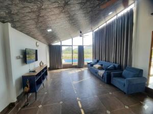 a living room with a blue couch and a tv at CP Villa Resort in Bhāweghar