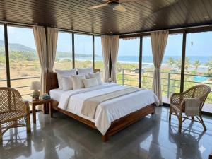 a bedroom with a bed with a view of the ocean at CP Villa Resort in Bhāweghar