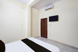 a bedroom with a bed and a tv on the wall at Hotel O Sector 12 Ghaziabad Formerly VIP Inn in Ghaziabad